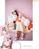 A woman sitting on the ground with a bunch of stuffed animals.