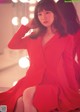 A woman in a red dress sitting in front of a mirror.