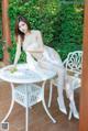 A woman sitting on top of a white table.