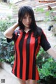 A woman in a red and black striped shirt posing for a picture.