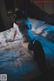 A woman laying on a bed wearing a pair of headphones.