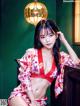 A woman in a red and white kimono sitting on a chair.